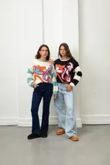 Buzo de punto con diseño de flores abstractas en colores vibrantes y mangas a rayas. Presenta cuello redondo y puños tejidos.