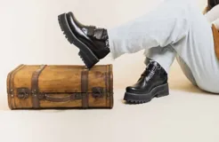 Botas cortas de cuero negro con ajuste mediante hebillas y suela track.