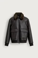Campera de cuero sintético marrón oscuro, de corte relaxed fit, con cuello de corderito sintético desmontable, bolsillos frontales con solapa, puños y cintura elasticados en rib, y cierre frontal de cremallera.