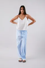 Pantalón celeste a rayas verticales blancas, de corte palazzo y cintura alta con elástico.