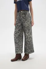 Pantalon de jean de corte ancho y tiro alto, con diseño estampado animal print en tonos grisáceos. Presenta pinzas en la cintura y ruedo con doblez.