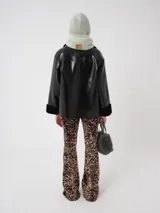 Campera oversized de cuero sintético negro con interior de piel sintética al tono, solapas amplias, cierre frontal y puños con detalle de piel.