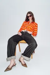 Zapato destalonado de piel en color marrón, con diseño de punta fina y tacón kitten. Incluye una tira trasera ajustable con hebilla metálica dorada.