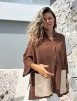 Saco tejido de punto en color marrón chocolate, con corte holgado y mangas anchas. Presenta cierre frontal con botones y dos bolsillos delanteros grandes en material metalizado color champán.