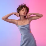 Vestido midi celeste de satén, con breteles finos y corte en la cintura.