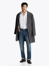 Camisa blanca de corte slim fit, con cuello abotonado, cierre con botones y logo de Tommy Hilfiger bordado en el pecho.