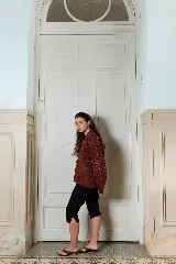 Campera tejida de fit oversized, con diseño de rayas que combinan distintas técnicas de tejido y relieves ondulados, cuello redondo y cierre frontal con nudos.