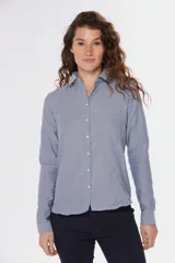 Camisa celeste de corte clásico, con cuello abotonado y mangas largas.