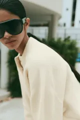 Jersey de punto color marrón, de cuello redondo y manga larga, con cierre frontal parcial de botones.