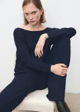 Pantalón azul marino de tiro medio, corte ancho y recto, con pequeñas aberturas en los bajos.