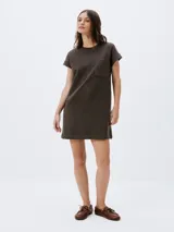 Vestido corto negro de manga corta, con corte recto, escote redondo y un bolsillo aplicado en el pecho.