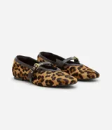 Zapatilla estilo Mary Jane de cuero con estampado animal print de leopardo. Presenta una tira superior ajustable con hebilla metálica dorada y detalles de ribete en color marrón oscuro.