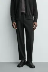Pantalón de corte regular fit, color negro, confeccionado en tejido elástico. Presenta cintura elástica, cierre frontal con cremallera y botón, bolsillos laterales y bolsillos traseros de vivo.
