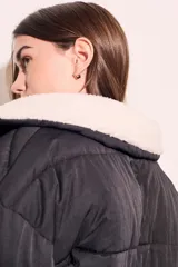 Campera puffer negra con cuello de corderito color crema, cierre frontal con cremallera y cordón ajustable en el ruedo.