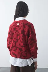 Sweater de punto con diseño estampado de hojas en tonos azul claro y azul oscuro. Presenta cuello redondo, mangas largas y terminaciones acanaladas en puños y ruedo.