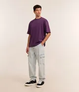 Pantalón de jean estilo baggy, color celeste claro, con corte holgado, cintura con trabillas y bolsillos cargo laterales.