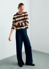 Pantalón de punto de corte recto y tiro alto, con cintura elástica y diseño fluido. Presenta una caída amplia y cómoda, ideal para un look sofisticado y relajado.