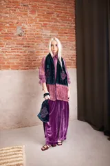 Cartera de mano tipo bolsa confeccionada en terciopelo de seda color verde petróleo, con diseño bordado en el frente y terminaciones con flecos largos en tono rosado.