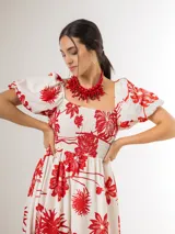 Vestido largo azul marino con estampado floral blanco, escote cuadrado con nido de abeja en el pecho y mangas abullonadas cortas.