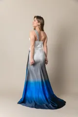 Vestido largo de fiesta en seda natural color marfil con degradé en tonos de azul. Diseño de un solo bretel con apliques bordados y tajo frontal.