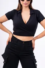 Top negro de punto canalé con cuello tipo chomba, corte cropped y diseño cruzado con abertura en la cintura.