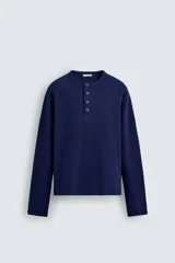 Camiseta de manga larga con cuello redondo y cierre frontal de botonadura tipo henley, confeccionada en tejido de punto con textura waffle.