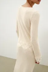Top de tejido rústico color beige con cuello redondo y mangas largas, con aplicación de crochet a tono en los puños y el ruedo.
