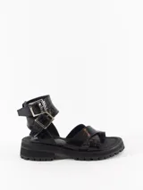 Sandalia negra de cuero con textura tipo cocodrilo, plataforma track y hebillas plateadas.