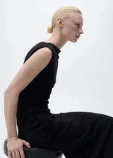 Vestido midi de diseño entallado, confeccionado en tejido de modal y algodón. Presenta cuello asimétrico, sin mangas y detalle de drapeado en la cintura.