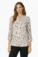 Blusa de viscosa con estampado abstracto en tonos marrones sobre fondo blanco. Presenta cuello en V, cierre frontal con botones, mangas largas y dos bolsillos delanteros con solapa.