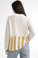 Sweater de algodón de corte holgado con cuello redondo. Presenta un diseño jacquard con un sol bordado en el centro, cuello en color celeste y puños con franjas celestes.