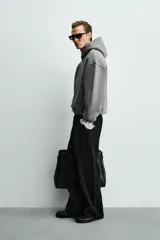 Sudadera tipo hoodie de corte boxy fit, confeccionada en tejido doble y compacto de mezcla de algodón. Presenta cuello con capucha, manga larga y acabados en el mismo tejido.