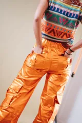 Pantalón cargo color naranja metalizado, de corte recto y tiro alto, con bolsillos laterales con solapa y bolsillos traseros con cierre.