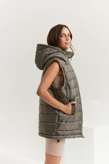 Chaleco verde militar con cierre frontal, bolsillos laterales y capucha forrada.