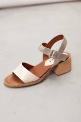 Sandalia de cuero marrón con tira frontal en cuero y correa al tobillo metalizada con hebilla ajustable. Cuenta con tacón ancho y bajo de acabado símil madera.