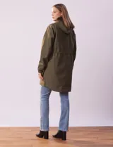 Gabardina impermeable color beige, marca Weatherproof, con cierre central, bolsillos delanteros con botones a presión, capucha desmontable y forro interno.