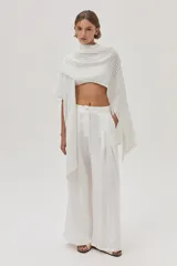 Ruana tejida con detalle de lurex, de diseño abierto y sin mangas, con escote en V profundo y ajuste mediante cinturón en la cintura.