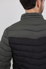 Campera capitoneada con capucha, con cambio de color tipo colorblock en verde militar y negro.