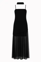Vestido largo negro confeccionado en crepé y gasa, de corte al cuerpo con escote recto, tiritas finas y falda larga semitransparente con tajo lateral pronunciado. Incluye accesorio tipo corbatín a juego.