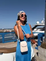 Bandolera pequeña tipo porta celular, color verde claro, confeccionada en cuero sintético. Cuenta con cierre principal, bolsillo frontal con tapa y broche a presión, y correa ajustable extraíble.