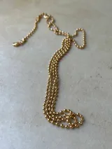 Collar dorado con cadena de bolitas.