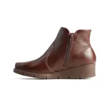 Bota casual tipo chelsea de cuero marrón con textura granulada, diseño de caña baja con paneles elásticos laterales y suela de taco corrido al tono.