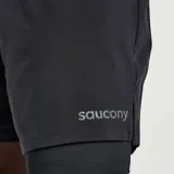 Short deportivo Saucony Outpace de 7 pulgadas, color negro, con short interior de 8/25 pulgadas, pretina elástica con cordón, paneles perforados para mayor transpirabilidad, bolsillos laterales y bolsillo trasero con cremallera.