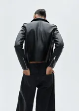 Chaqueta biker de piel ovino color negro, con cuello de solapa y cierre frontal de cremallera.