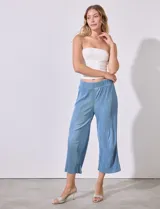 Pantalón capri de satén plisado color celeste, marca Cyrus, con pretina ancha elastizada.