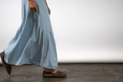 Falda larga de lino en color crudo, con diseño de paneles verticales y corte acampanado.