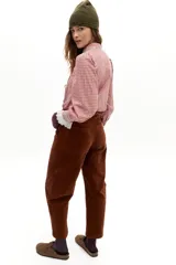 Pantalón de corte barrel relajado confeccionado en corduroy de algodón con un toque de spandex. Presenta un diseño de tiro medio con bolsillos laterales y cierre frontal.