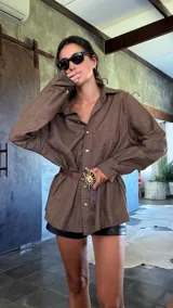 Cinturón de cuero marrón con hebilla metálica dorada en forma de sol con rayos.