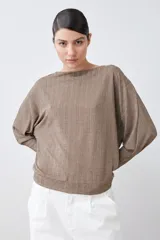 Blusa roja de tejido de punto acanalado, con escote barco y mangas dolman largas.