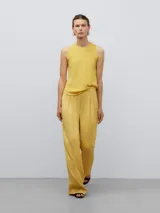 Pantalón recto amarillo con pinzas frontales, bolsillos inclinados y cintura sastre con goma interior.